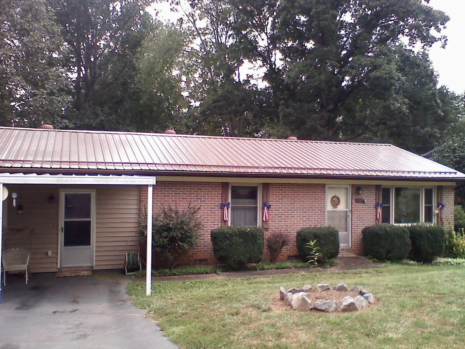 Bronze metal roof and carport on a brick ranch home — Roof Repair work by our crew in Anoka